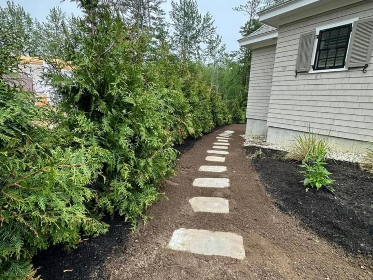 Stone steps between planting beds beside a home