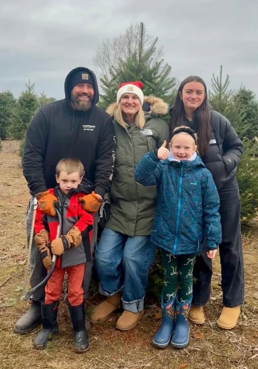 The Thompson family standing outdoors together